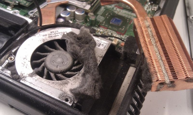 An illustration of a laptop emitting steam with a warning sign, symbolizing overheating due to heavy load.